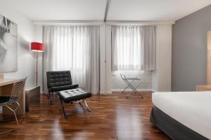 a bedroom with a bed and a chair and a desk at Eurostars Marqués de Vallejo in Logroño