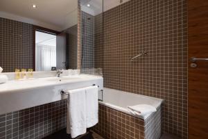a bathroom with a sink and a tub and a mirror at Eurostars Marqués de Vallejo in Logroño