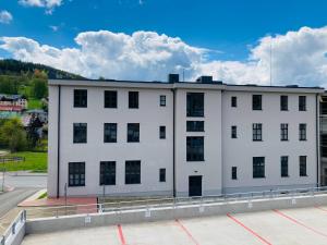 a white building with black windows on a street at Residence Kotel in Rokytnice nad Jizerou
