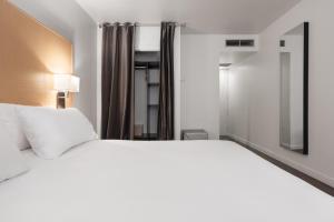 a bedroom with a large white bed and a mirror at Eurostars Marqués de Vallejo in Logroño