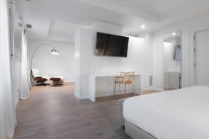 a white bedroom with a bed and a desk at Eurostars Marqués de Vallejo in Logroño