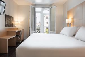 a hotel room with a bed and a desk and a window at Eurostars Marqués de Vallejo in Logroño