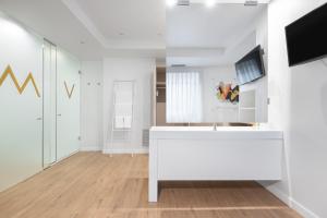 a white room with a tv and a white desk at Eurostars Marqués de Vallejo in Logroño