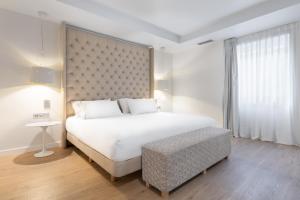 a bedroom with a large white bed and a table at Eurostars Marqués de Vallejo in Logroño