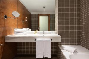 a bathroom with a sink and a toilet and a mirror at Eurostars Marqués de Vallejo in Logroño