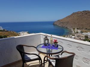 een tafel en stoelen op een balkon met uitzicht op de oceaan bij Sea View Apartments by Susi & Sofia in Skala