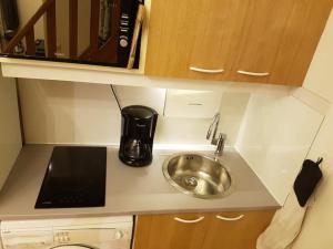 a kitchen counter with a sink and a coffee maker at Le Jardin des Alpilles in Eyguières