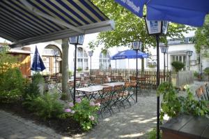 a group of tables and chairs with umbrellas at Gasthof Zur Post in Wolnzach