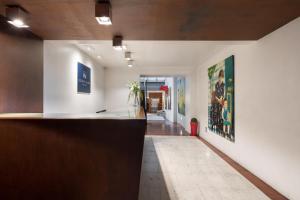 a hallway with a counter and paintings on the walls at Eurostars Marqués de Vallejo in Logroño
