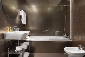 a bathroom with a sink and a tub and a toilet at Eurostars Marqués de Vallejo in Logroño