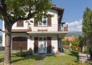 a house with a balcony and a tree at CASA ISA in Bellagio