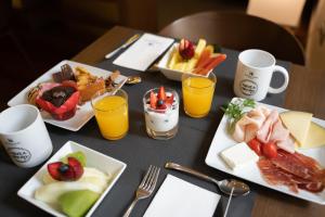a table with plates of food and glasses of orange juice at Eurostars Marqués de Vallejo in Logroño