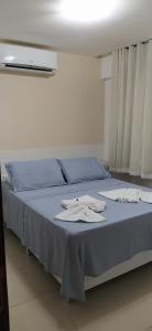 a bed with blue sheets and white towels on it at Sol e Mar Solar do Atlântico in João Pessoa