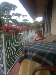 een balkon met een tafel en een hek met bloemen bij Maison La Vela in Forte dei Marmi