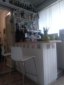 een kleine keuken met een wit aanrecht en stoelen bij Maison La Vela in Forte dei Marmi