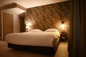 a bedroom with a large bed with a floral wallpaper at Hôtel Les Muses in Annecy