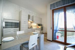 cocina con mesa, sillas y ventana en Appartamento Marevivo en Francavilla al Mare