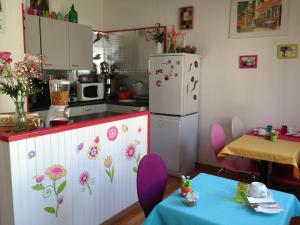kuchnia z fioletowymi krzesłami i białą lodówką w obiekcie Hôtel de La Poste w mieście Douvaine
