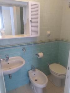 een badkamer met een wastafel, een toilet en een spiegel bij Maison La Vela in Forte dei Marmi