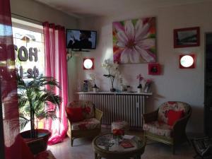 a living room with two chairs and a table at Hôtel de La Poste in Douvaine