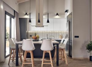 eine Küche mit einem schwarzen Tisch und weißen Stühlen in der Unterkunft Villa Belen in Kypseli
