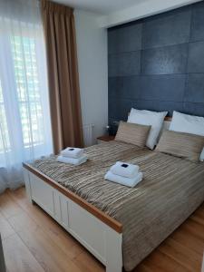 sypialnia z dużym łóżkiem z dwoma ręcznikami w obiekcie Aqua Apartments Sunset w Redzie