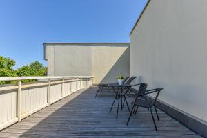 a patio with chairs and a table on a balcony at Alka Boutique Apartments & SPA in Palanga +32 photos