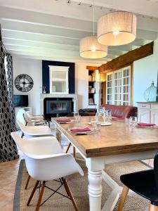 La Gervaiserie - 300m de la plage في Réville: غرفة معيشة مع طاولة وكراسي خشبية