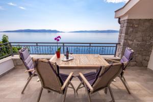 d'une table et de chaises sur un balcon avec vue sur l'eau. dans l'établissement Villa Arca Adriatica, à Sveti Juraj