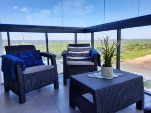 a porch with chairs and a table with a view at Aqua Apartments Sunset in Reda