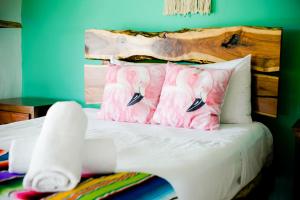 1 dormitorio con 1 cama con almohadas rosas de flamenco en PENINSULA STAYS 3BR House Tiburón Ballena BEST in HOLBOX en Holbox Island