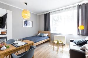 a small living room with a bed and a table at Wonderful Apartments in the Center of Krakow in Kraków