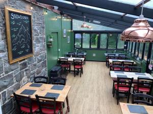 a restaurant with tables and chairs and a chalkboard on the wall at The Heights Bunkhouse in Llanberis