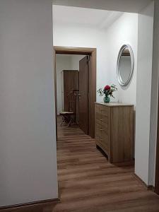 a hallway of a room with a dresser and a mirror at Dany Apartments in Gevgelija
