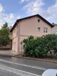 a pink and white building on the side of a street at Dany Apartments in Gevgelija
