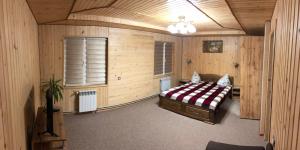a bedroom with a bed in a room with wooden walls at Карпатська ніч in Plav'ya