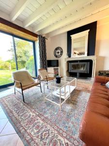 a living room with a couch and a table at La Gervaiserie - 300m de la plage in Réville