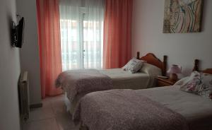 Tempat tidur dalam kamar di Pensión Residencia Miñones