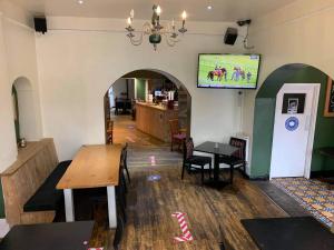 a restaurant with a table and a tv on the wall at The Heights Bunkhouse in Llanberis