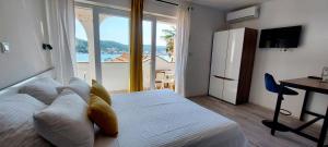 a bedroom with a bed and a desk and a window at Guest House Galeb in Supetarska Draga