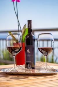 a bottle of wine and two glasses on a table at Villa Arca Adriatica in Sveti Juraj