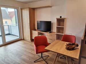 a living room with a table and two chairs and a television at Ferienwohnung Thaya in Thaya