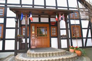 budynek z drewnianymi drzwiami z flagami w obiekcie Hotel Alte Schule w mieście Luhden