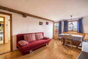 a living room with a red couch and a table at Ferienwohnung Enzian Nusserhof in Avelengo