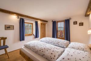 a bedroom with a bed with blue curtains at Ferienwohnung Enzian Nusserhof in Avelengo