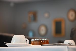 a table with a cup and saucers on a table at Hôtel Les Muses in Annecy