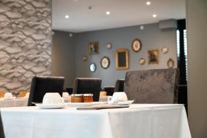 a table with plates and napkins on top of it at Hôtel Les Muses in Annecy
