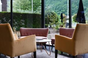 a room with three chairs and a table and a window at Hôtel Les Muses in Annecy