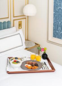 a tray of breakfast food on a bed at Meliá London Kensington Member of Meliá Collection in London