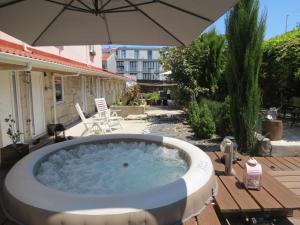 a hot tub on a deck with an umbrella at Ruby Charm Houses 2 AL in Porto
